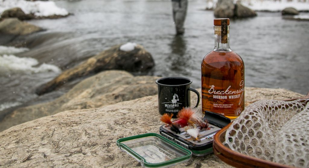 whiskey with fishing lures in front of river