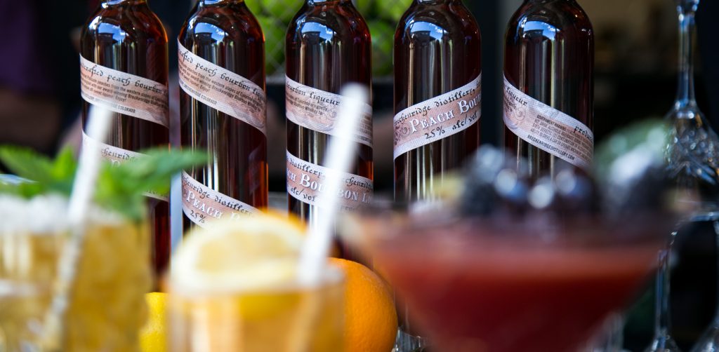 peach bourbon liqueur bottles with cocktails