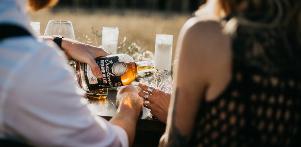 people pouring whiskey