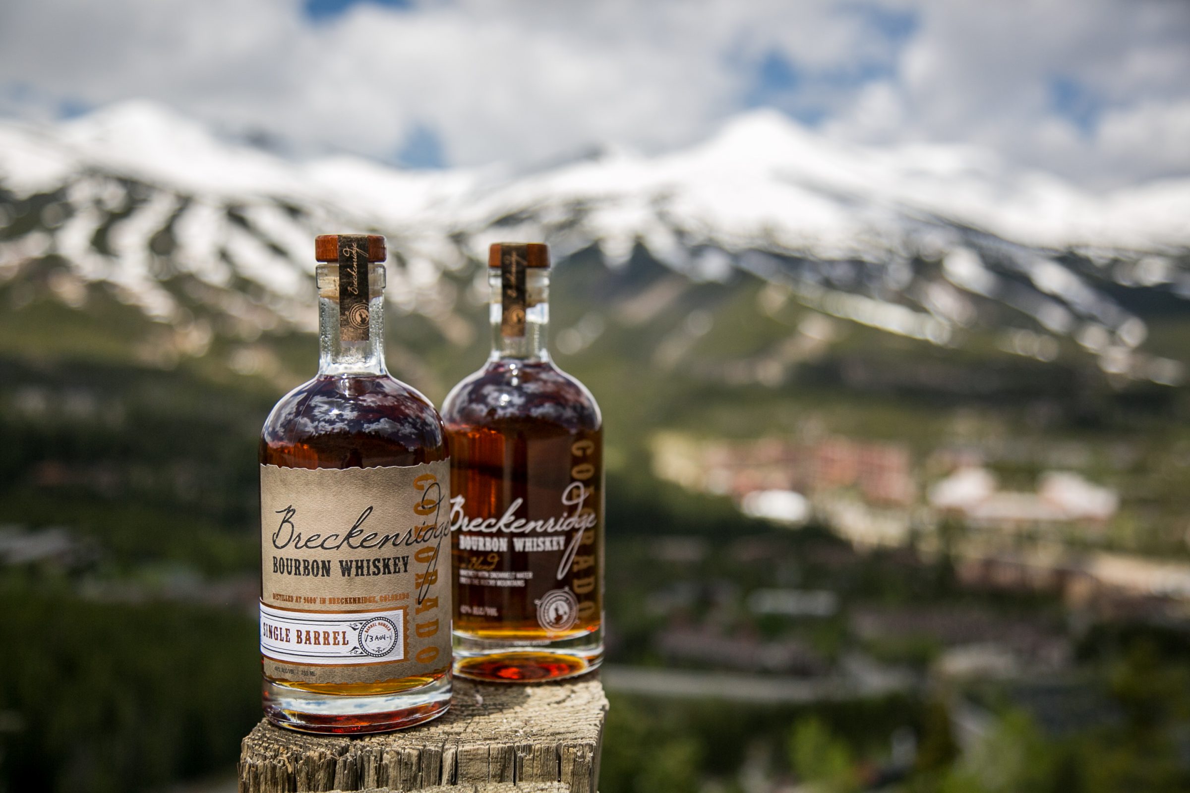 two bottles of whiskey in front of mountain scenery