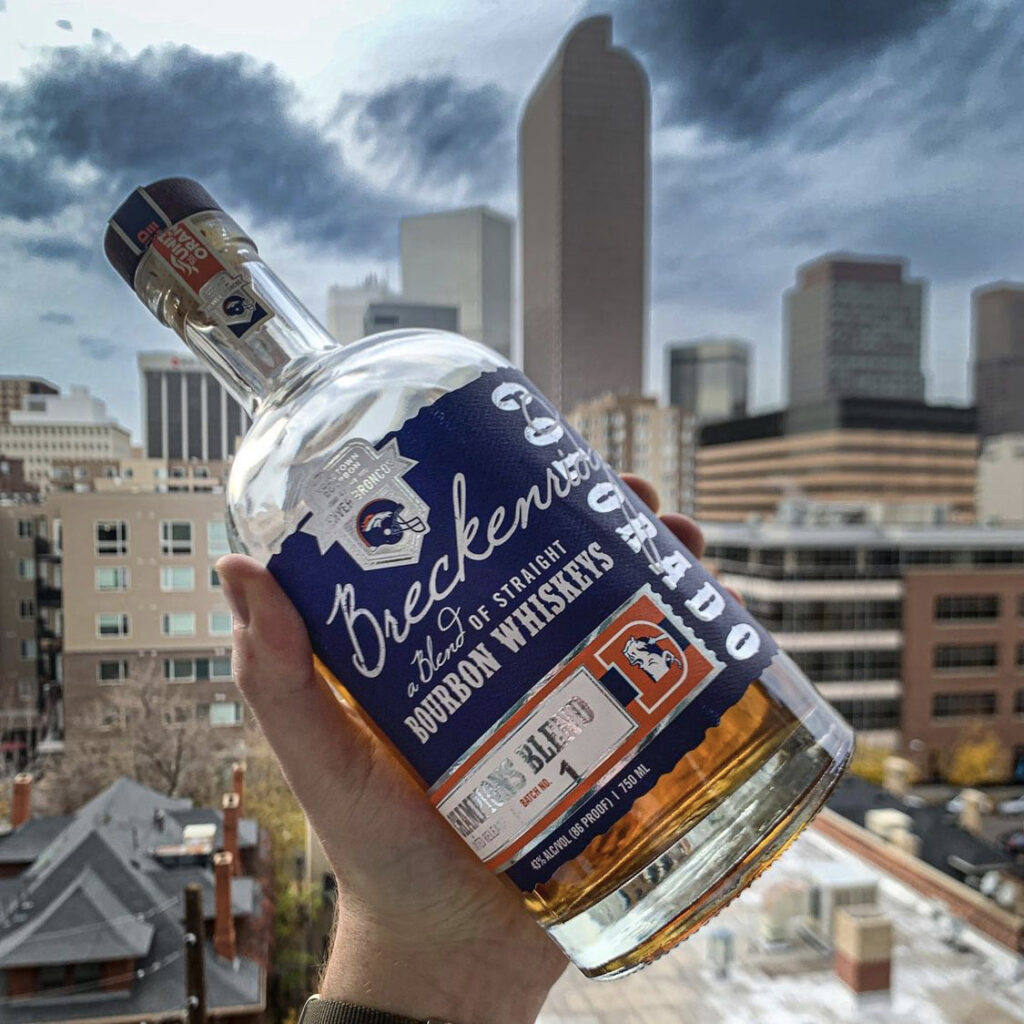 @dramgoodbourbon Blue Edition Denver Broncos Breckenridge Bourbon Whiskey Bottle in front of cityscape